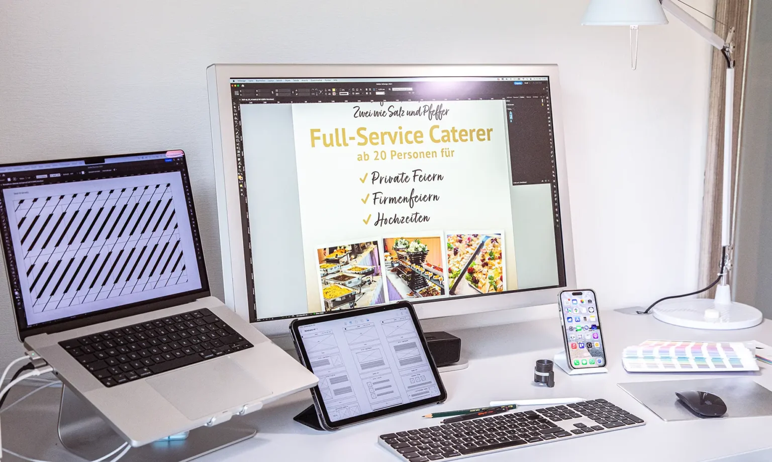 Ein stilvoller Grafikdesign-Arbeitsplatz von SuperD3sign mit einem MacBook Pro auf einem Schreibtisch.